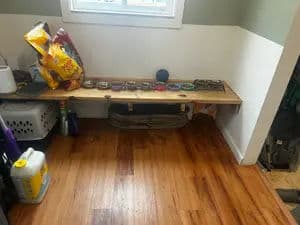 Wooden bench with tools and snacks in a tidy indoor space with hardwood flooring.