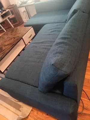Blue sectional sofa with plush cushions in a cozy living room setting.