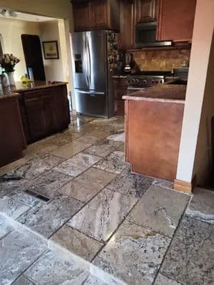 Modern kitchen with granite flooring, stainless steel appliances, and wooden cabinetry.