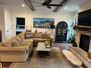 Cozy living room with sectional sofa, fireplace, and modern decor. Bright, inviting atmosphere.