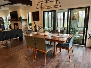 Modern dining room with a wooden table, stylish chairs, and large windows offering natural light.