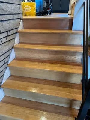 Modern wooden staircase with polished steps and stylish metal railing in a contemporary home.