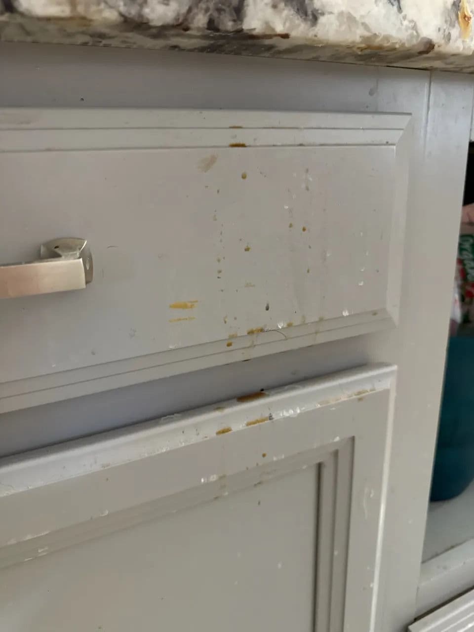 Kitchen cabinet with visible stains and water marks near the handle.